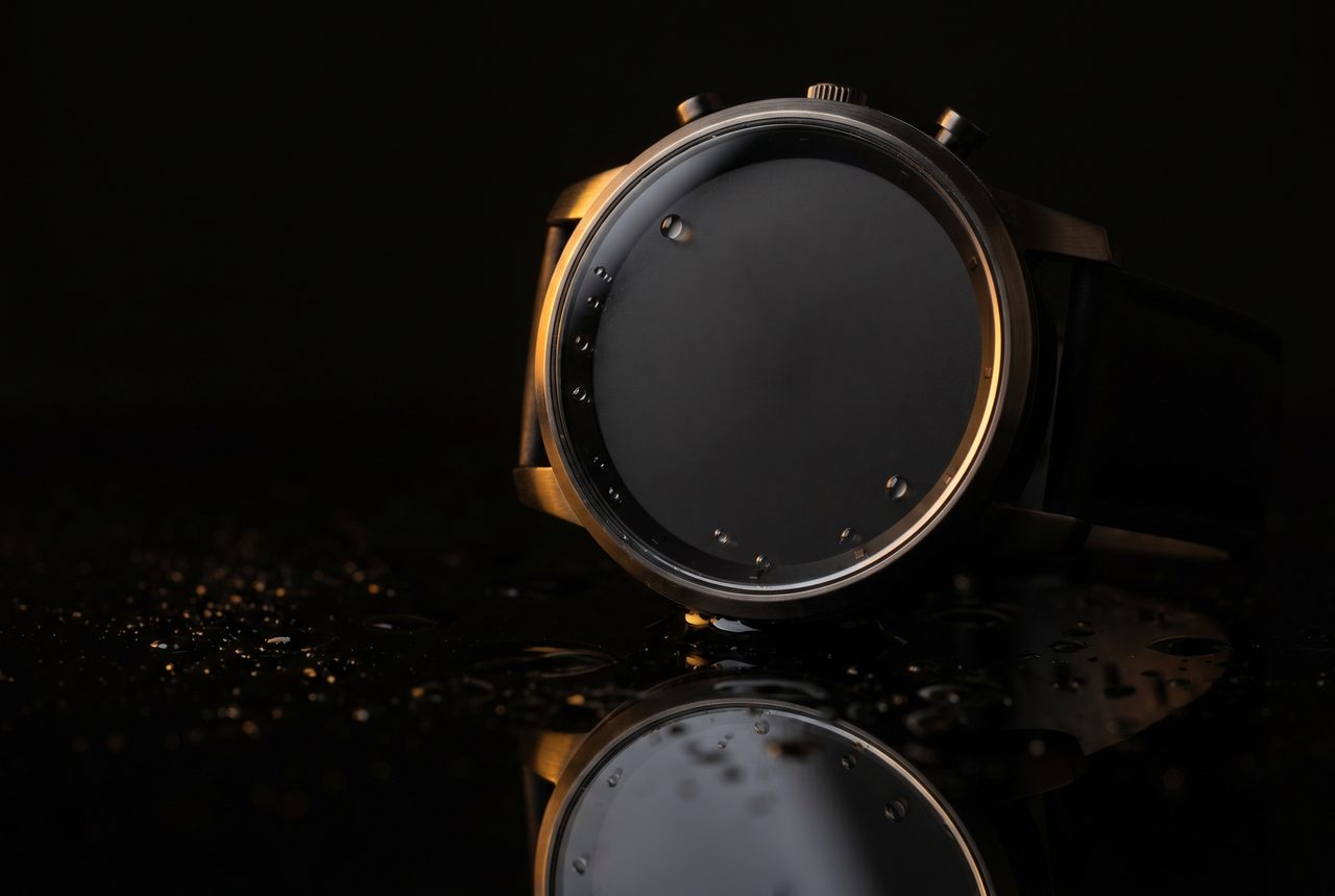 Crisp AI product static: macro still of a minimalist watch on wet black glass with amber highlights